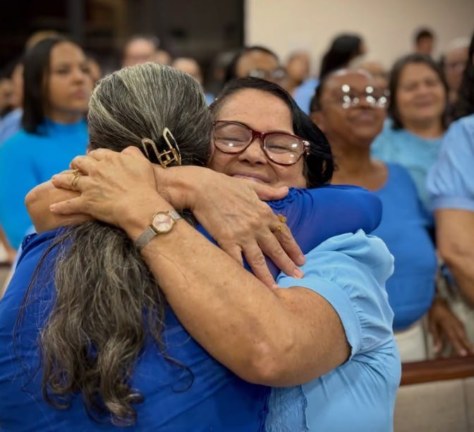 Duas irmãs se abraçando no culto