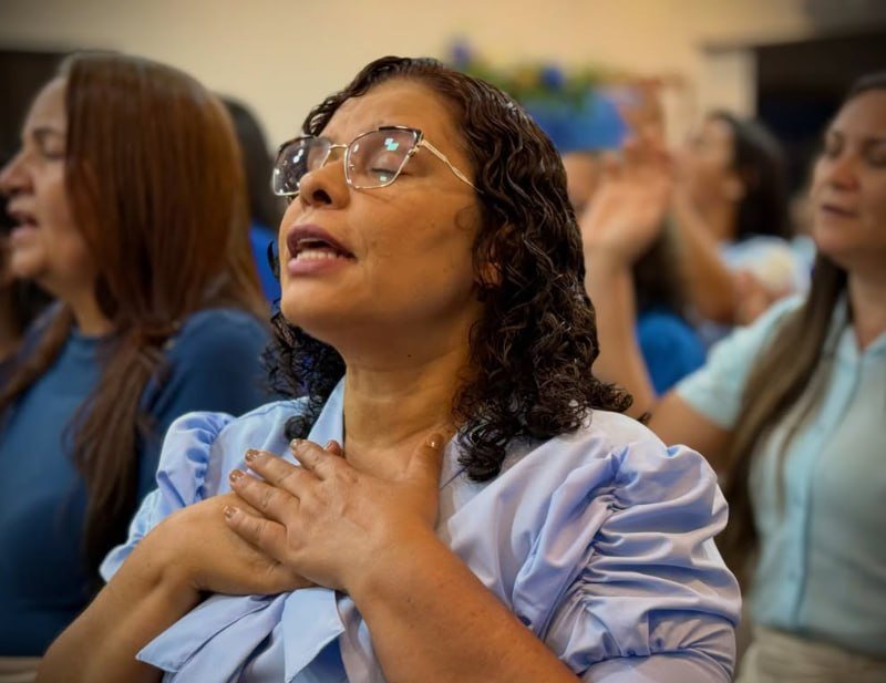 Irmã em oração durante o culto
