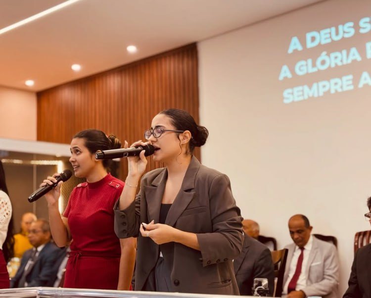 Irmãs cantando com microfone no louvor