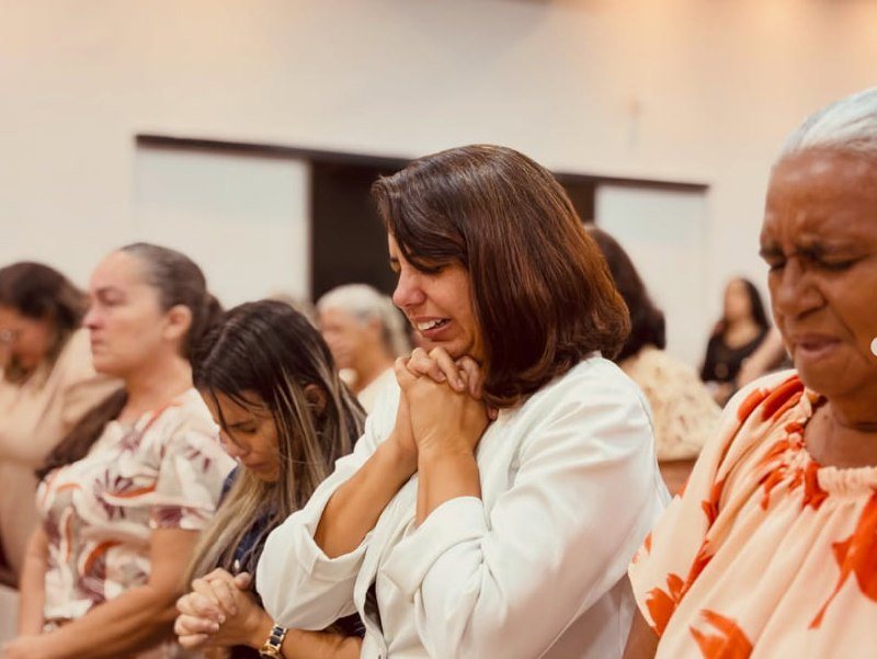 Irmãs orando de olhos fechados